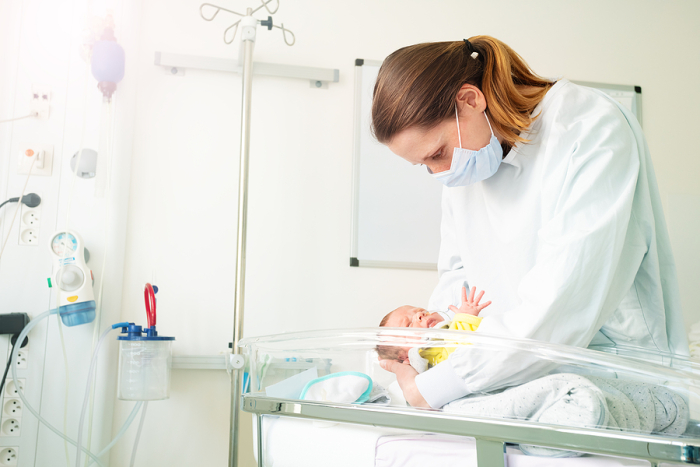 <p>Image of a mother in hospital with her preterm baby
